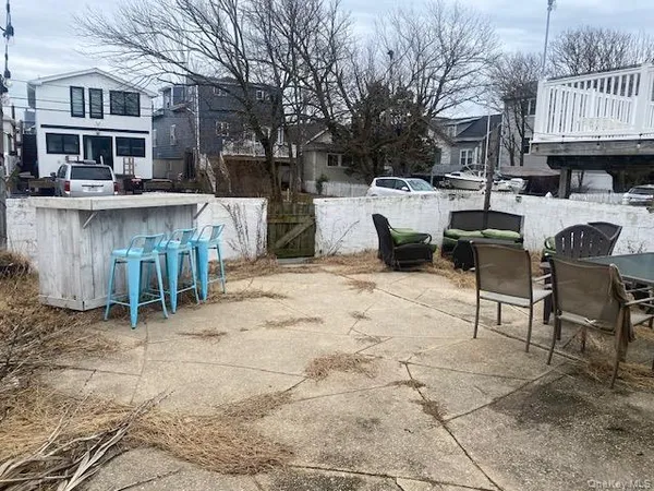 a view of a patio with table and chairs with wooden fence