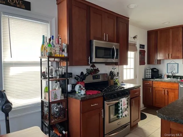 a kitchen with stainless steel appliances a stove a microwave and wooden cabinets