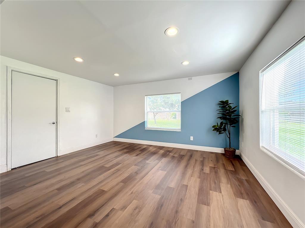 1613 Perkins Road Belle Isle, FL 32809 - Photo 15 of 37 Spacious Family room with new vinyl floors, new LED flushmount lighting, new blinds and new paint. Door leads to side yard.