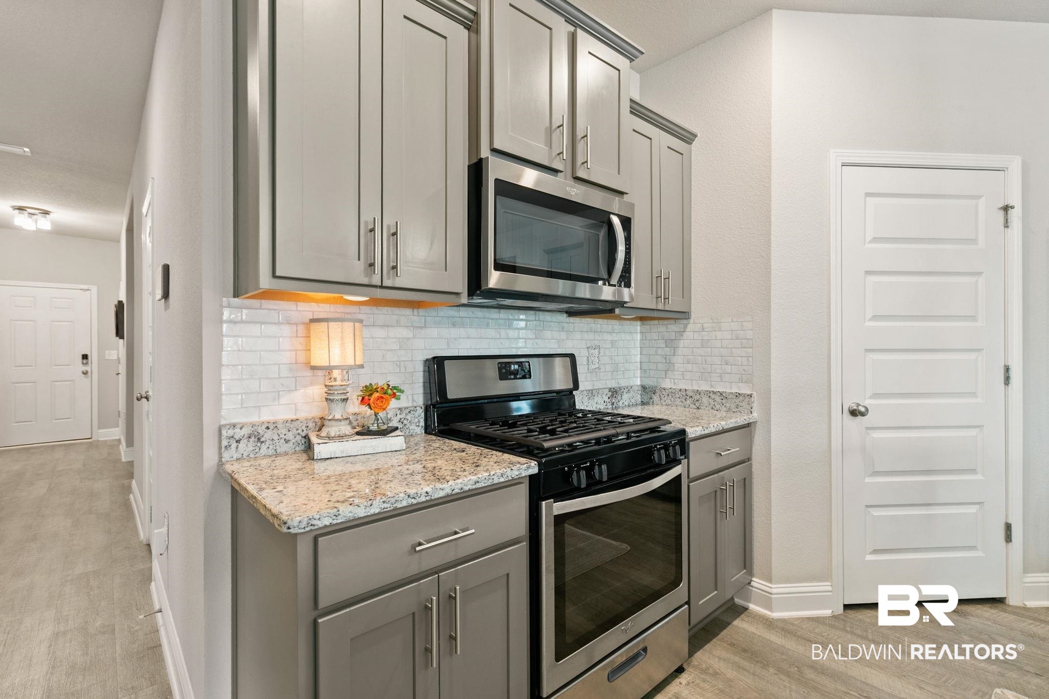31650 Memphis Loop Daphne, AL 36527 - Photo 8 of 68 Kitchen with stainless steel appliances, gray cabinets, light stone countertops, and light wood-style flooring