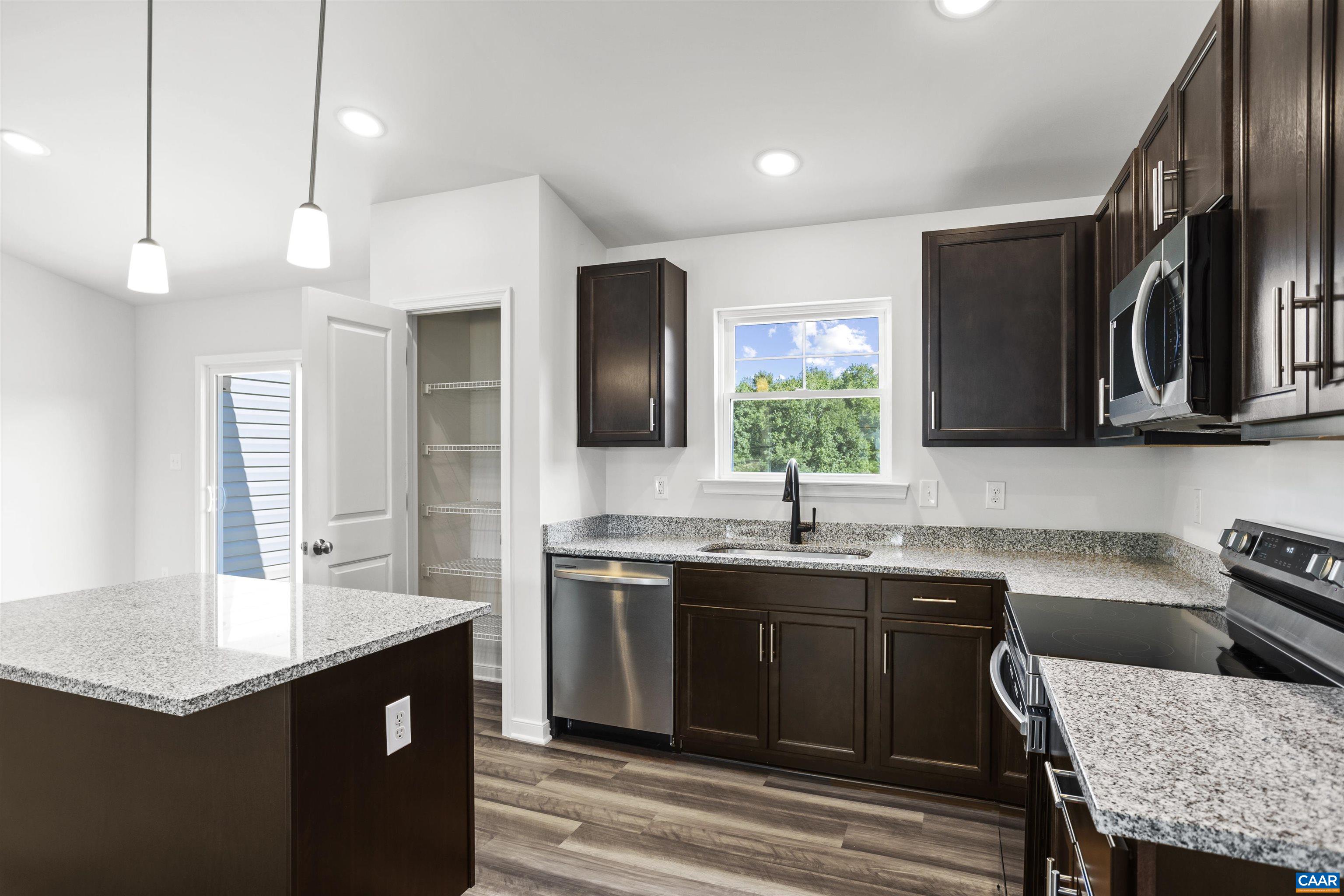 Lot 4 New Line Road Mineral, VA 23117 - Photo 8 of 20 a kitchen with a stove a sink a kitchen island with wooden cabinets and stainless steel appliances