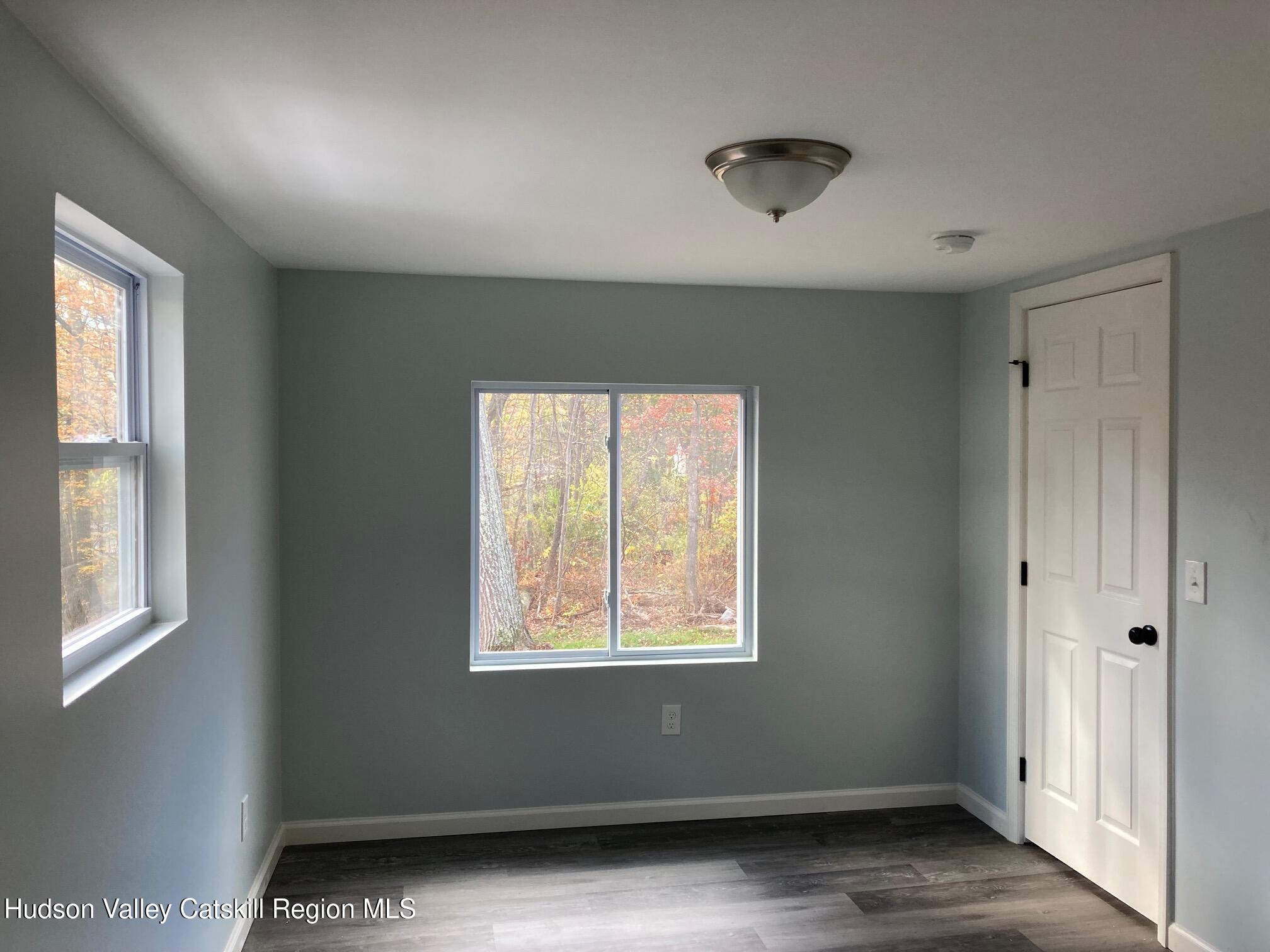 6 Elm Road Wurtsboro, NY 12790 - Photo 3 of 12 an empty room with wooden floor and windows