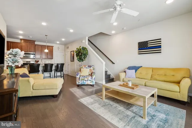 a living room with furniture kitchen view and a chandelier