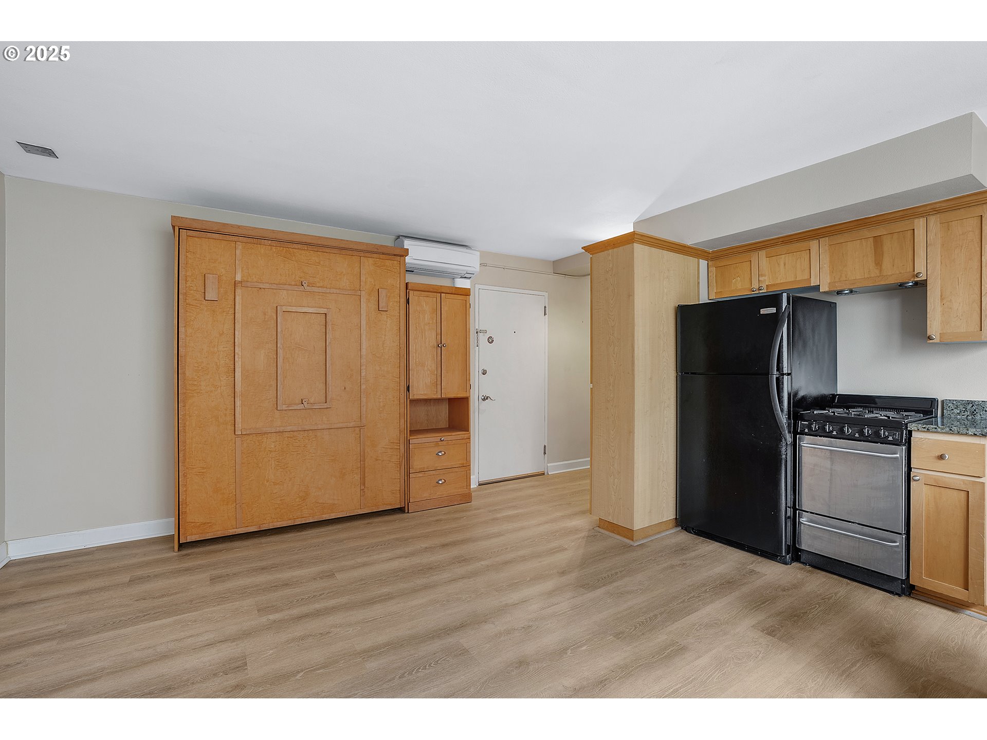 1205 Southwest Cardinell Drive, Unit 704 Portland, OR 97201 - Photo 10 of 23 a view of a kitchen with refrigerator and wooden floor