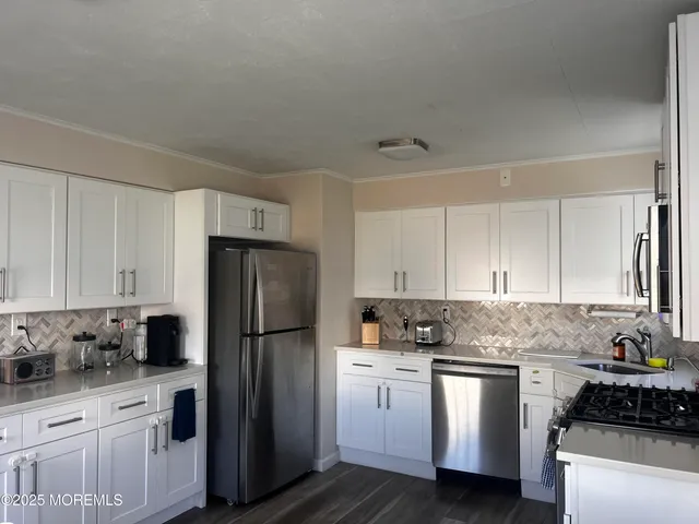 a kitchen with stainless steel appliances granite countertop a refrigerator stove and sink
