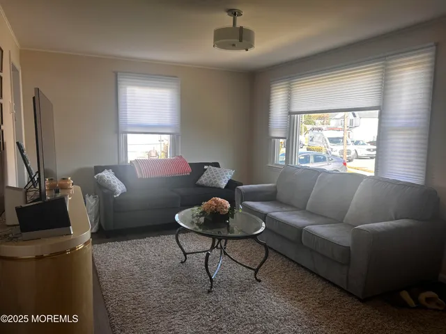 a living room with furniture a window and a flat screen tv