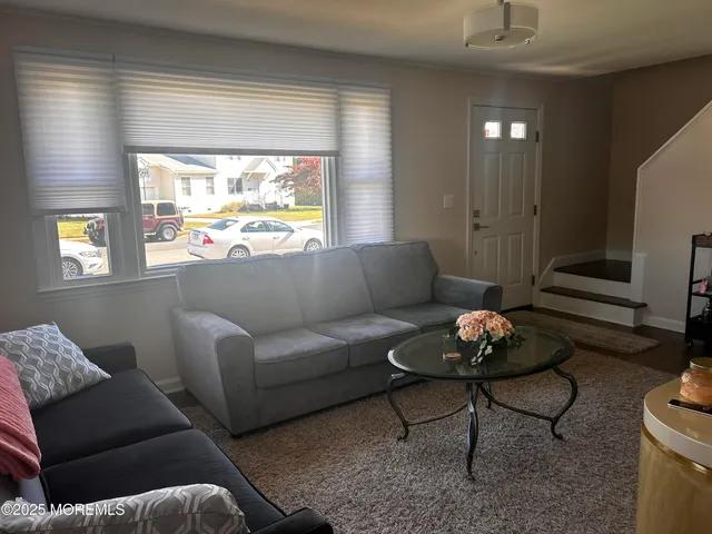 a living room with furniture a rug and a window