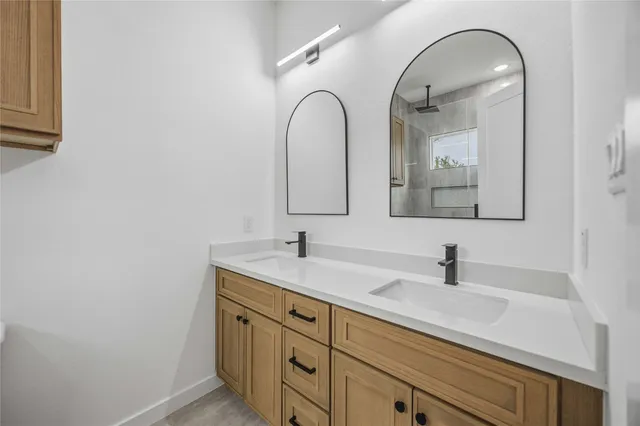 a bathroom with a double vanity sink and a mirror