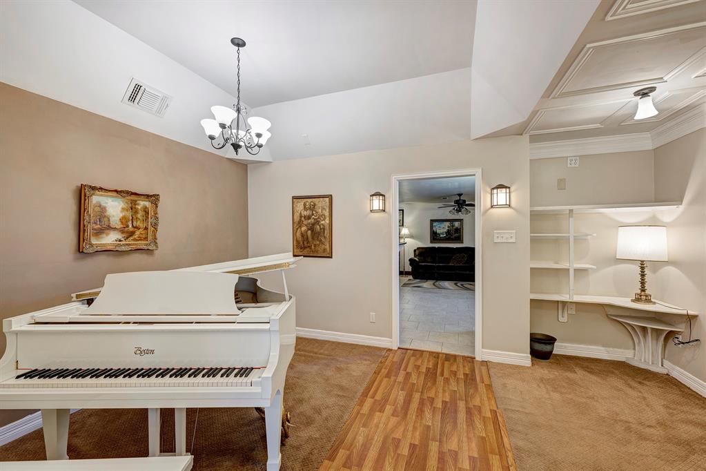a living room with a piano and a ceiling fan