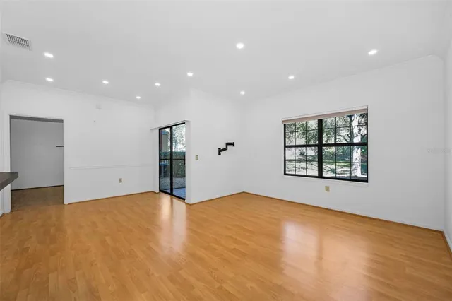 a view of empty room with wooden floor