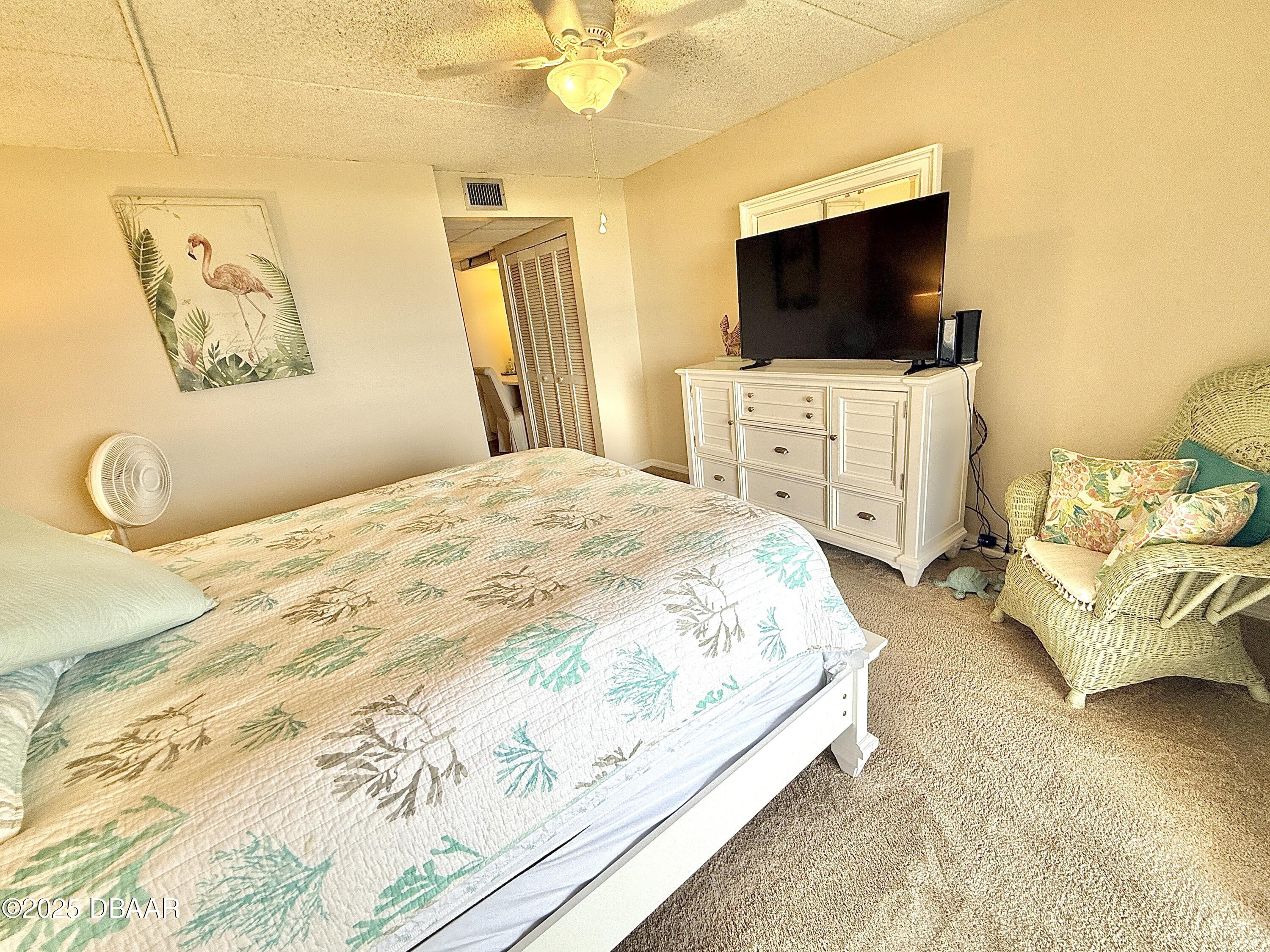 30 Inlet Harbor Road, Unit 606 Ponce Inlet, FL 32127 - Photo 18 of 45 a spacious bedroom with a bed and a flat screen tv