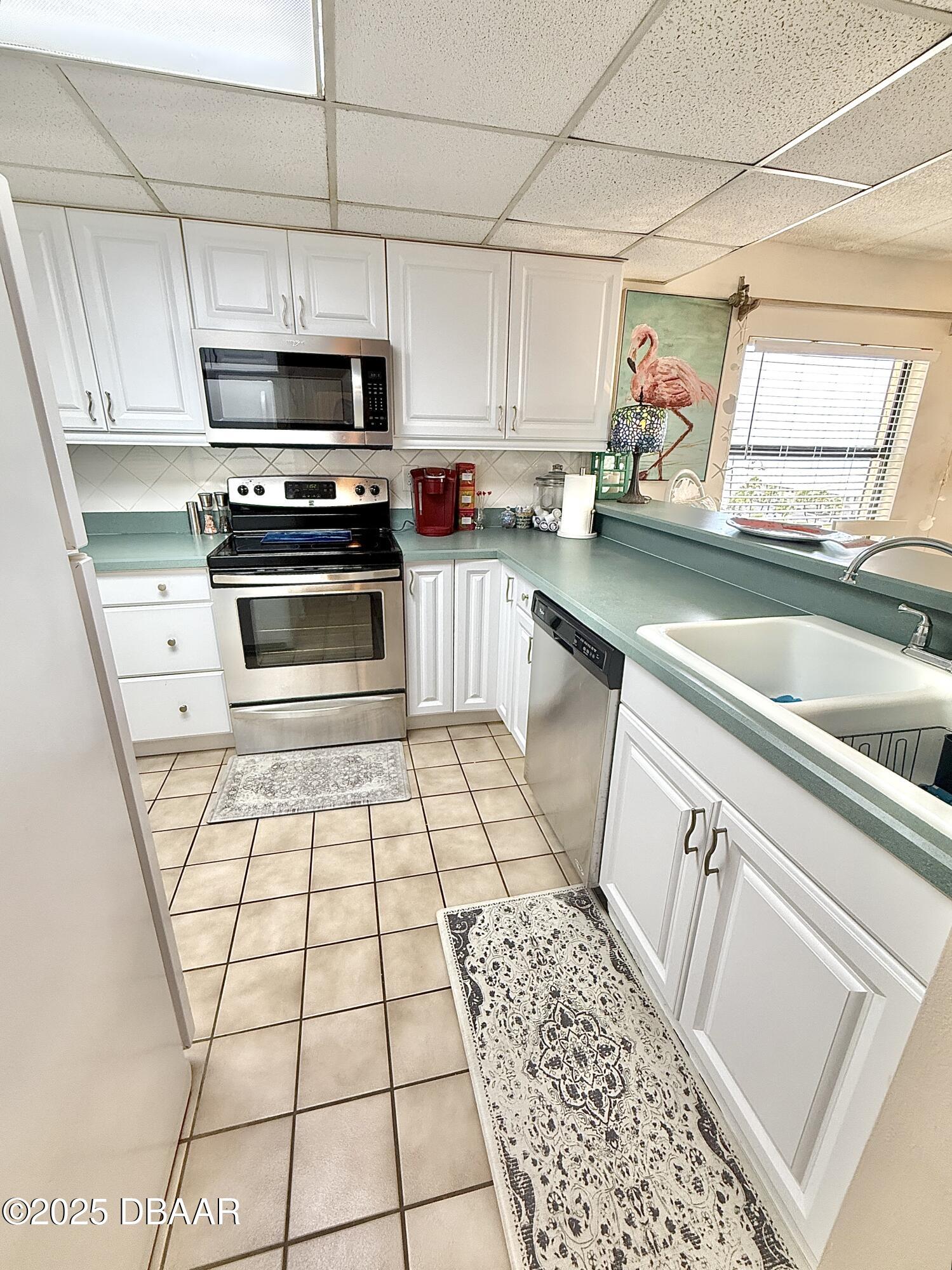 30 Inlet Harbor Road, Unit 606 Ponce Inlet, FL 32127 - Photo 28 of 45 a kitchen with stainless steel appliances a stove a sink and a microwave