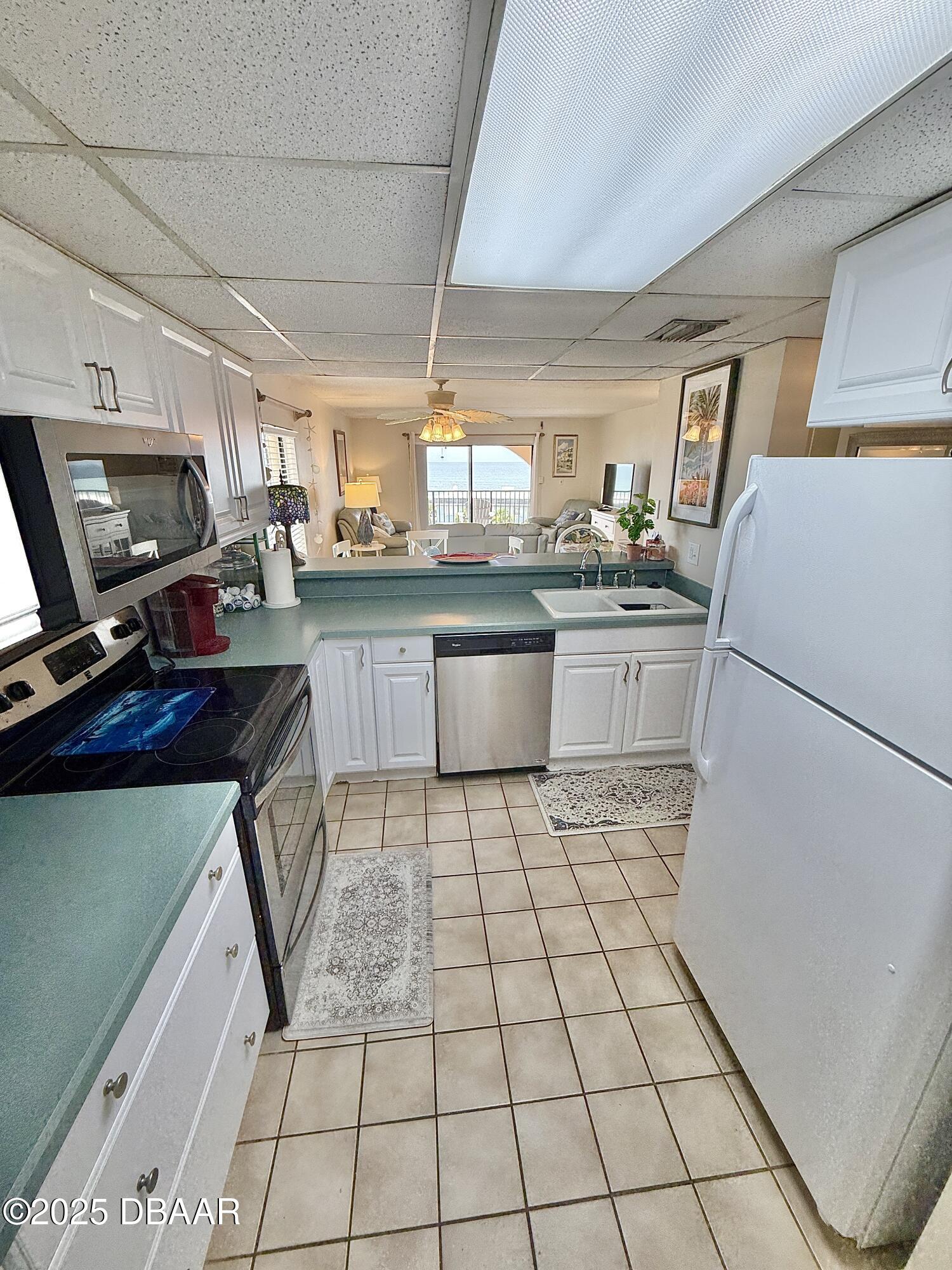 30 Inlet Harbor Road, Unit 606 Ponce Inlet, FL 32127 - Photo 32 of 45 a kitchen with a sink a stove a refrigerator and cabinets