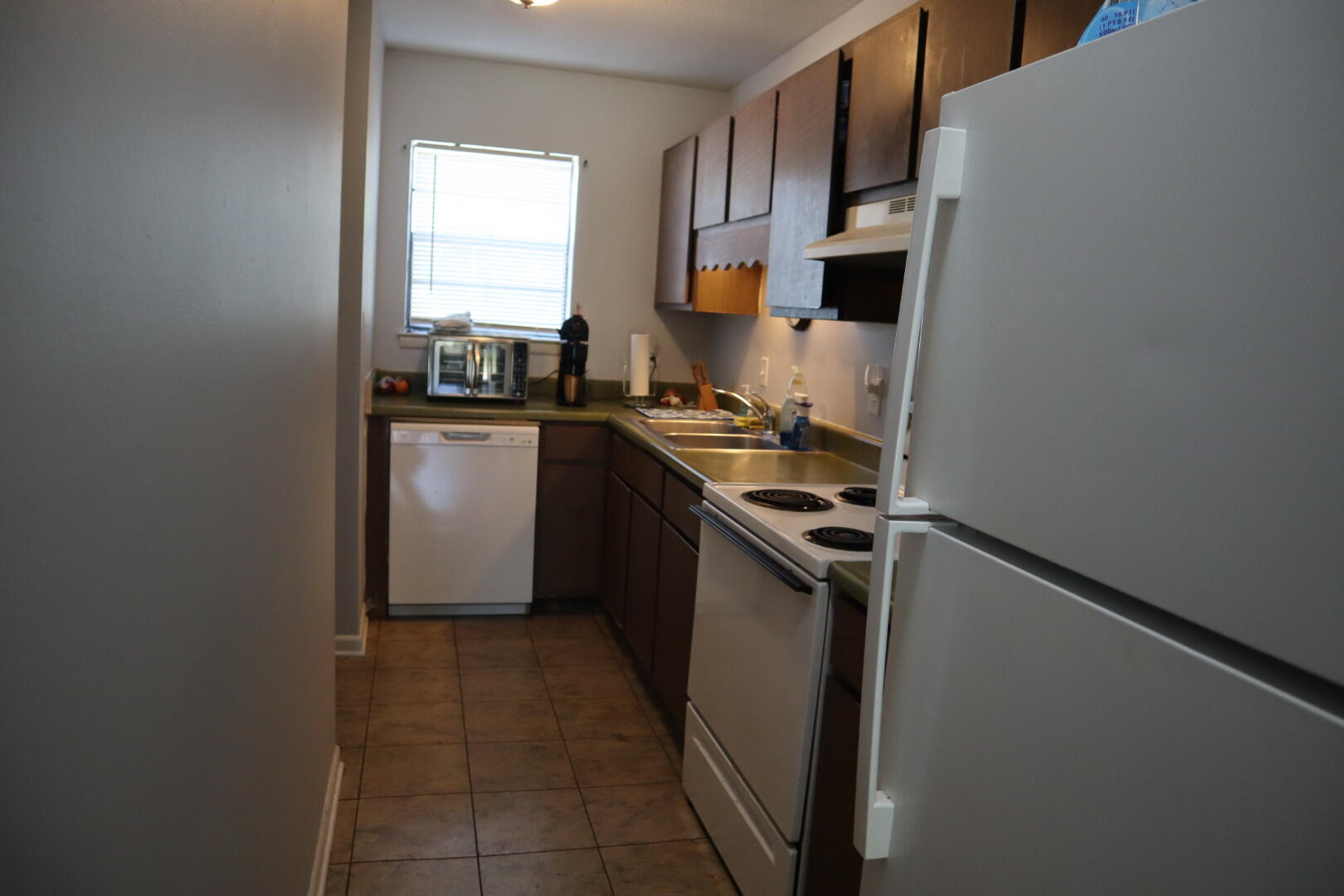 40 11th Street, Unit 99 Shalimar, FL 32579 - Photo 8 of 14 a kitchen with a sink a stove top oven and white stainless steel appliances