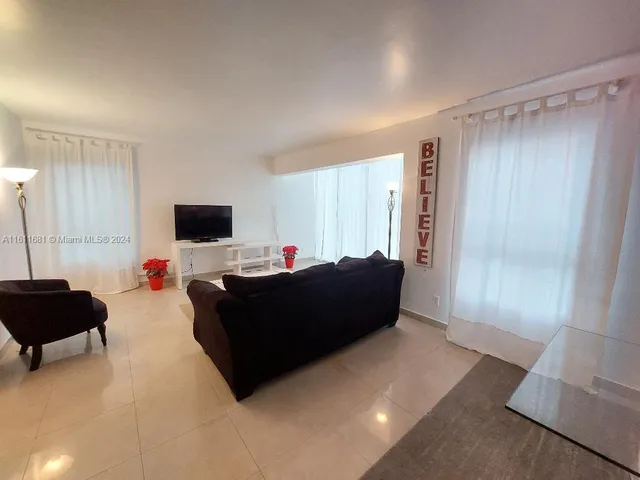 a bedroom with a bed and a lamp on dresser