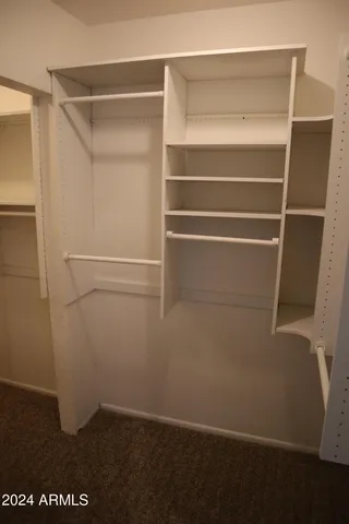 a view of walk in closet with empty racks
