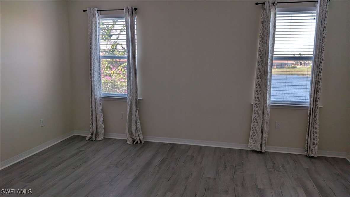 3552 Brittons Court Fort Myers, FL 33916 - Photo 19 of 27 an empty room with wooden floor and windows