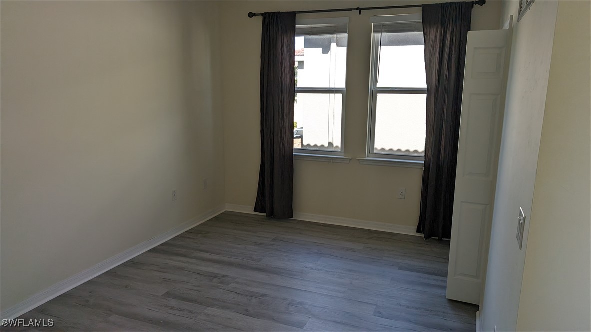 3552 Brittons Court Fort Myers, FL 33916 - Photo 23 of 27 an empty room with wooden floor and windows