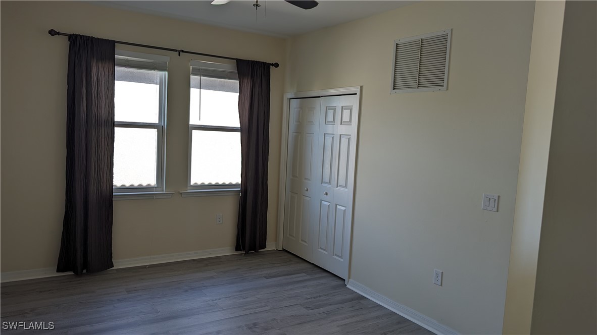 3552 Brittons Court Fort Myers, FL 33916 - Photo 24 of 27 an empty room with wooden floor and windows