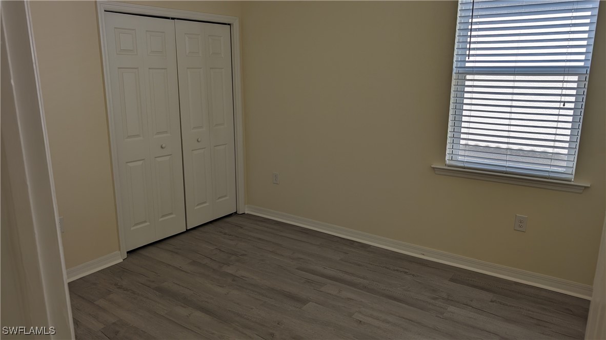 3552 Brittons Court Fort Myers, FL 33916 - Photo 26 of 27 an empty room with wooden floor and windows