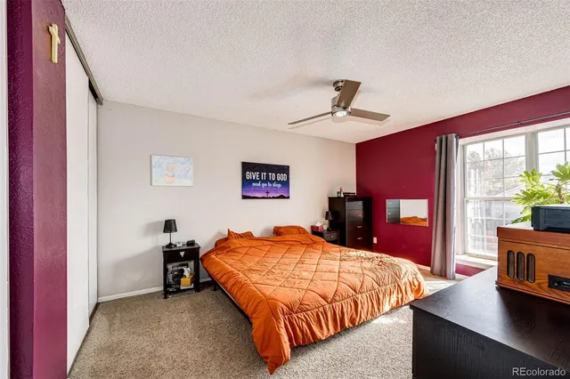 a bed sitting in a bedroom next to a window with a flat screen tv and dresser
