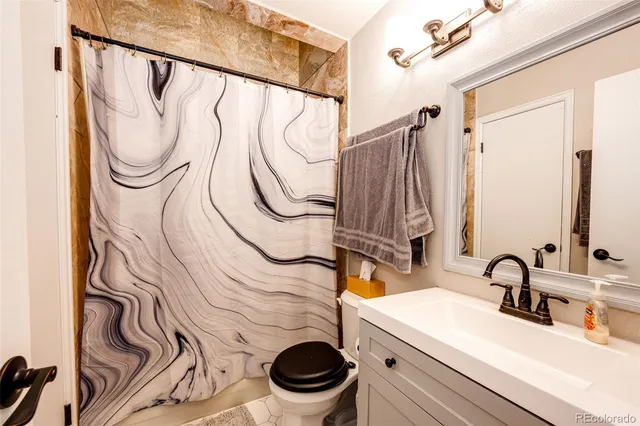 a bathroom with a sink a toilet and a mirror