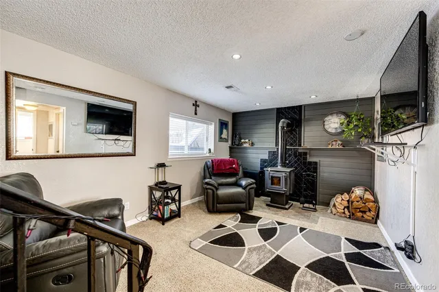 a room with furniture a flat screen tv and a view of kitchen