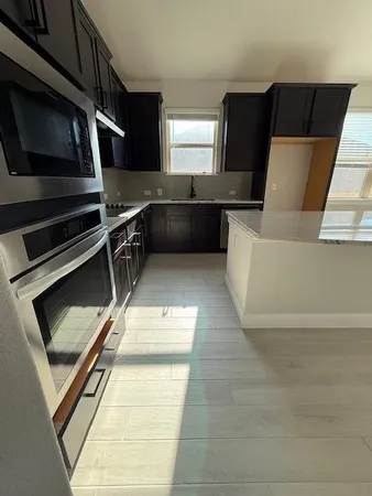 a kitchen with stainless steel appliances granite countertop a stove a refrigerator and a microwave oven