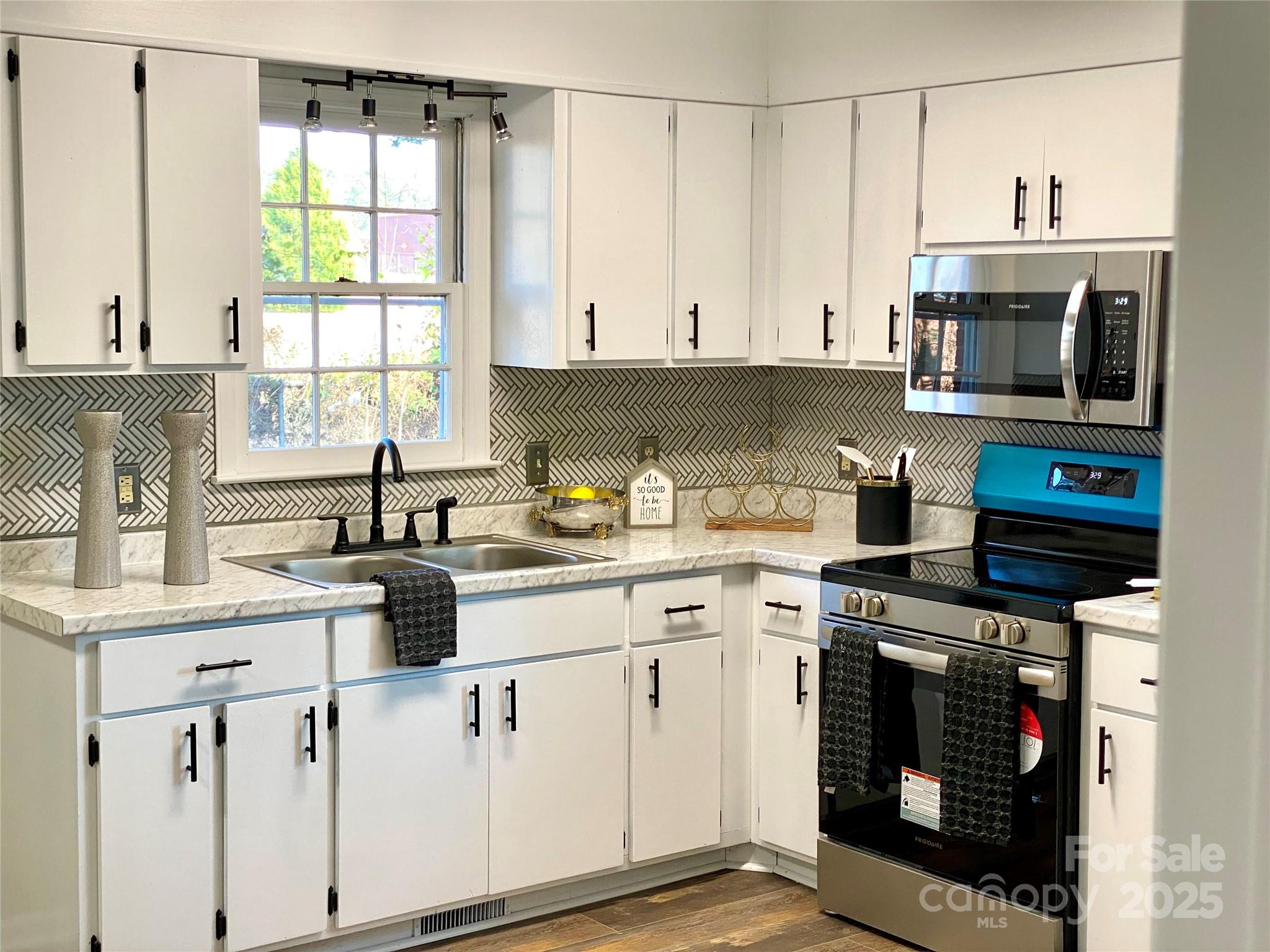 802 Marshall Street Cheraw, SC 29520 - Photo 5 of 16 a kitchen with stainless steel appliances granite countertop a stove a sink and a microwave