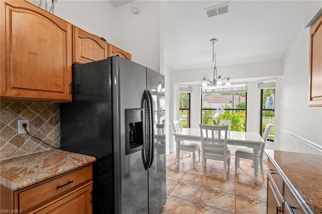 1348 Monarch Circle Naples, FL 34116 - Photo 11 of 33 a kitchen with a table chairs and refrigerator