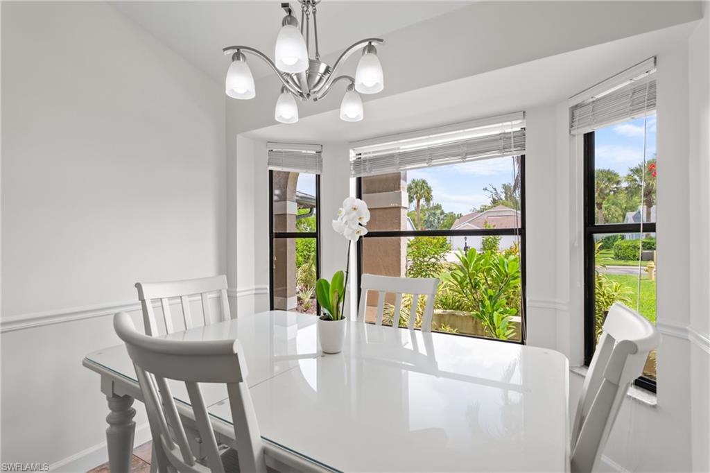 1348 Monarch Circle Naples, FL 34116 - Photo 12 of 33 a view of a dining room with furniture a chandelier and windows