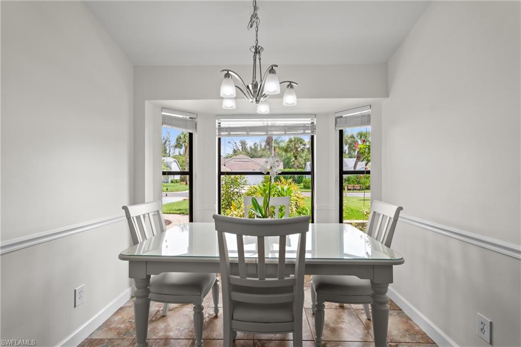 1348 Monarch Circle Naples, FL 34116 - Photo 13 of 33 a view of a dining room with furniture a chandelier and wooden floor