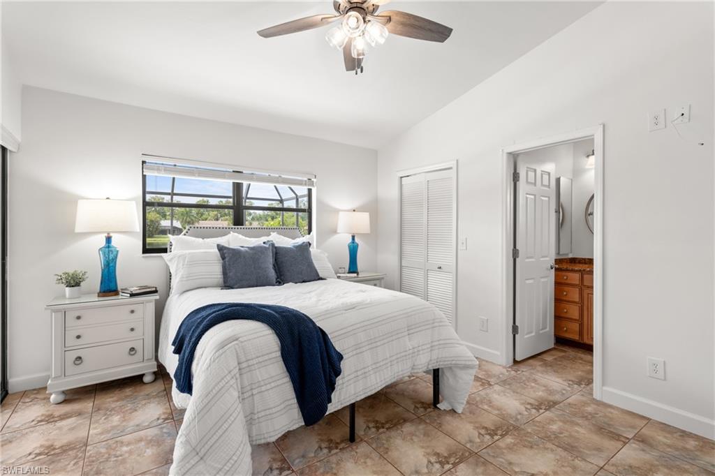 1348 Monarch Circle Naples, FL 34116 - Photo 14 of 33 a spacious bedroom with a bed and a chandelier