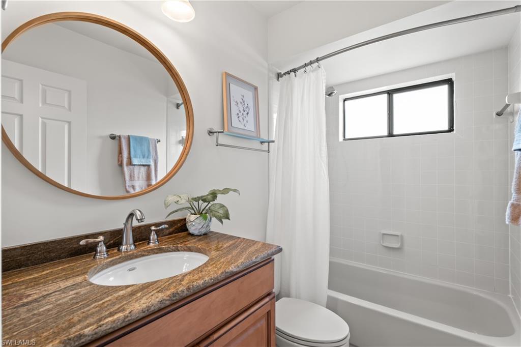 1348 Monarch Circle Naples, FL 34116 - Photo 19 of 33 a bathroom with a granite countertop sink toilet and a mirror