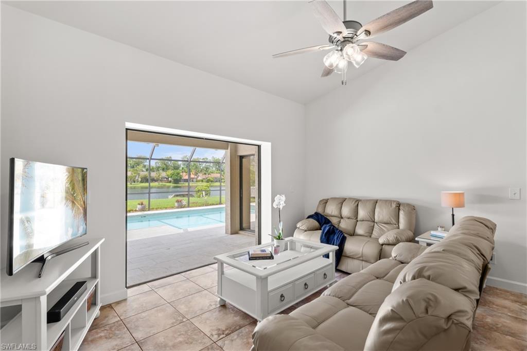 1348 Monarch Circle Naples, FL 34116 - Photo 4 of 33 a living room with furniture a flat screen tv and a large window