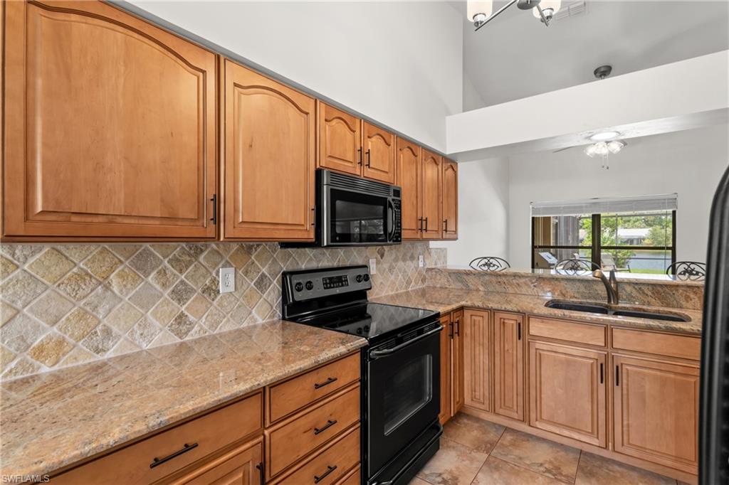 1348 Monarch Circle Naples, FL 34116 - Photo 9 of 33 a kitchen with granite countertop white cabinets and white appliances