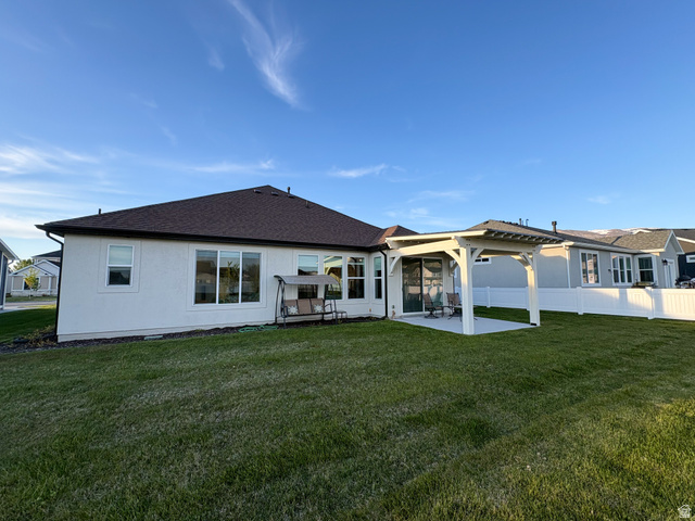412 West 3025th Street South Logan, UT 84321 - Photo 7 of 34 Rear view of house with a lawn, a patio area, and roof with shingles
