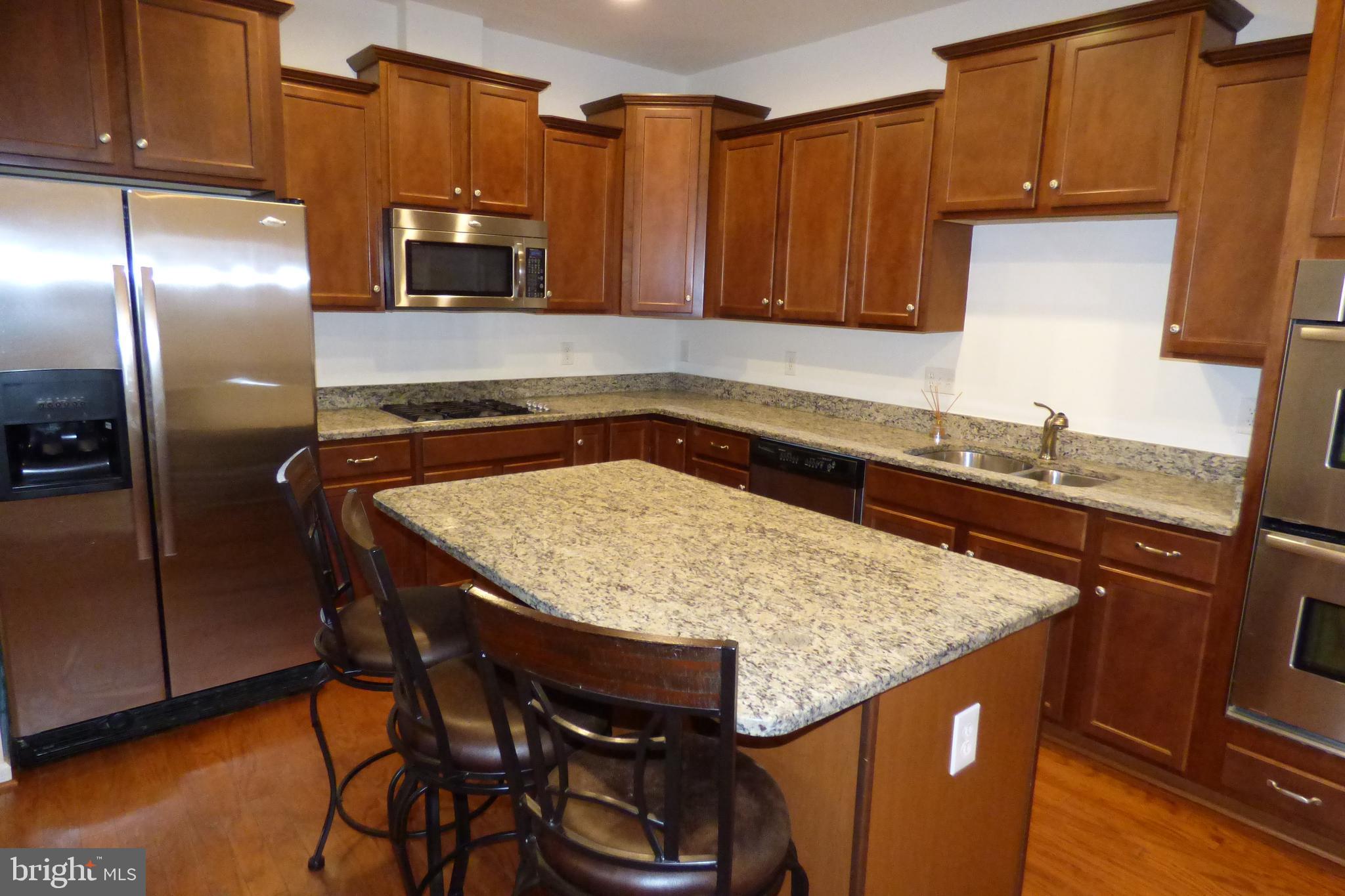 13113 Winding Trail Road Laurel, MD 20707 - Photo 18 of 47 a kitchen with granite countertop wood cabinets a sink and appliances