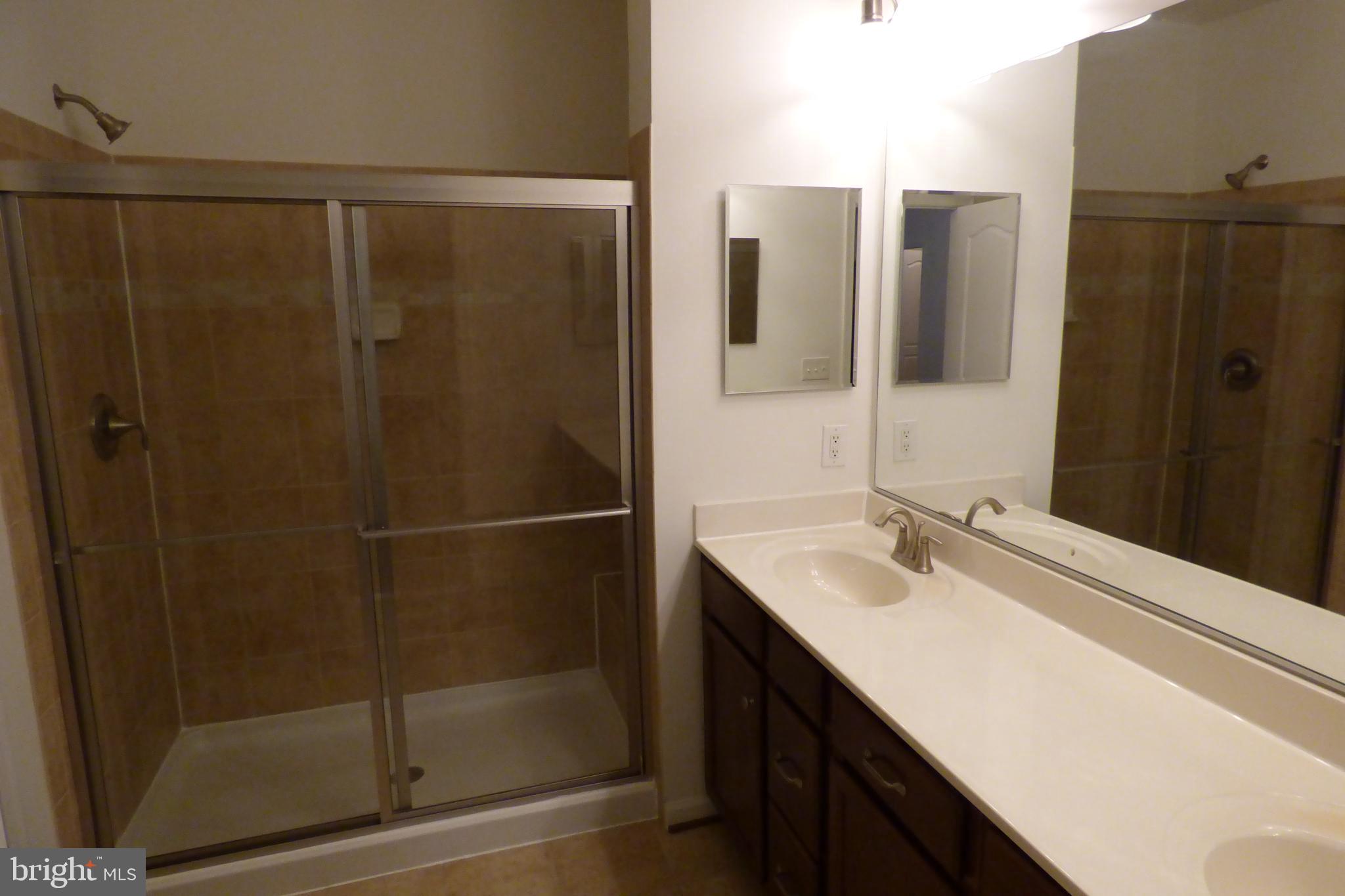 13113 Winding Trail Road Laurel, MD 20707 - Photo 27 of 47 a bathroom with a shower sink and mirror