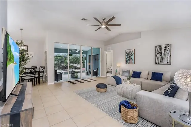 a living room with furniture a fireplace and a chandelier