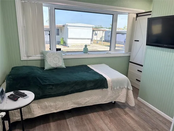 a living room with a bed furniture and a flat screen tv