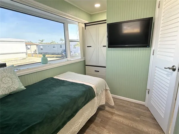 a bedroom with a bed and flat screen tv