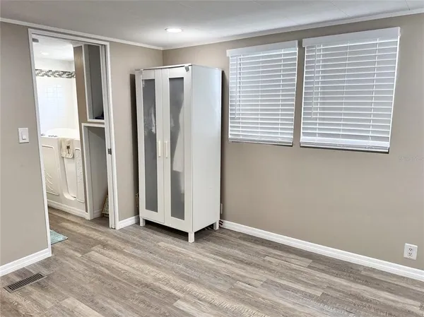 an empty room with wooden floor and a window