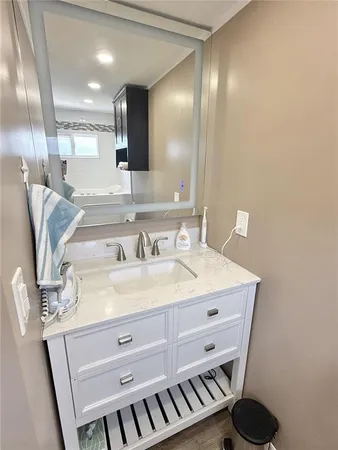 a bathroom with a sink a mirror and vanity