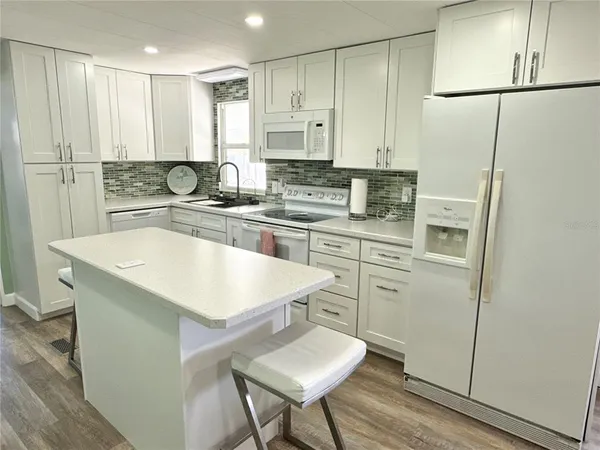 a kitchen with white cabinets and white appliances