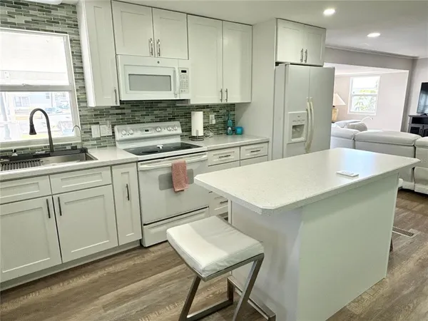 a kitchen with a sink a stove a refrigerator and cabinets