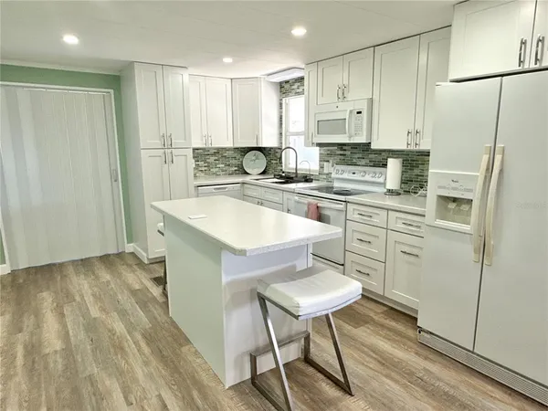 a kitchen with stainless steel appliances granite countertop a white cabinets and a refrigerator