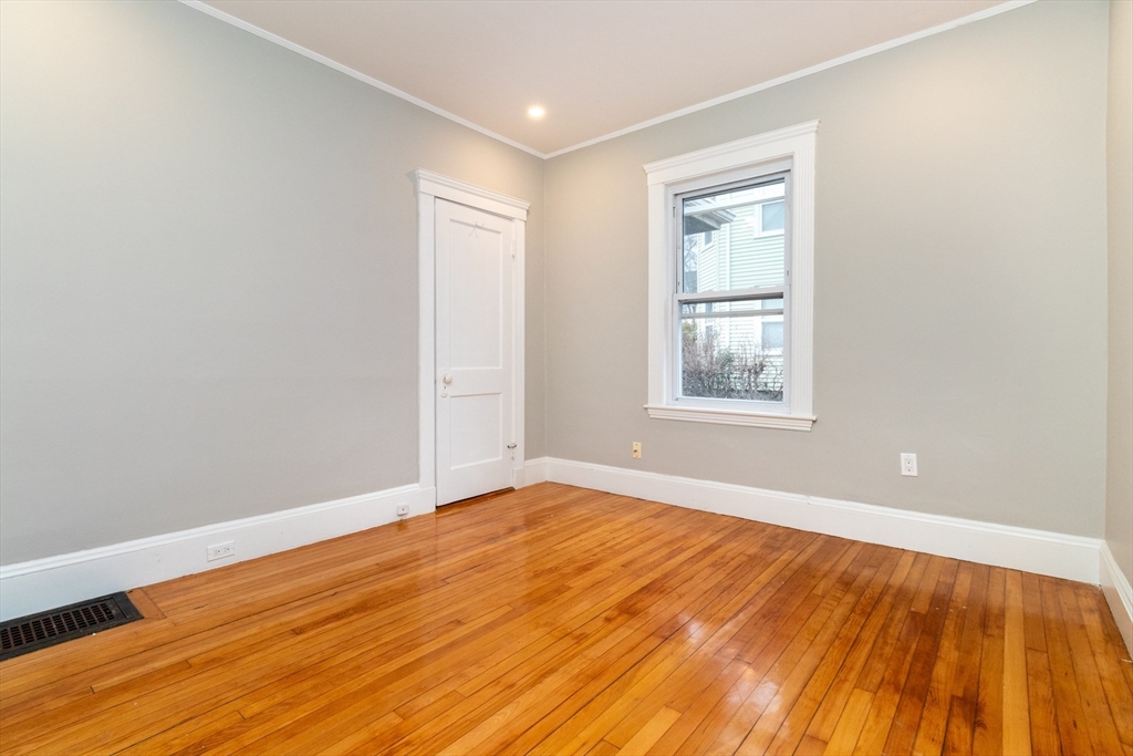 168 Brook Road Milton, MA 02186 - Photo 11 of 25 a view of an empty room with wooden floor and a window