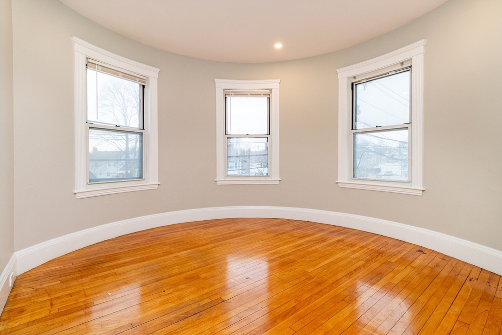 168 Brook Road Milton, MA 02186 - Photo 22 of 25 a view of an empty room with window and wooden floor