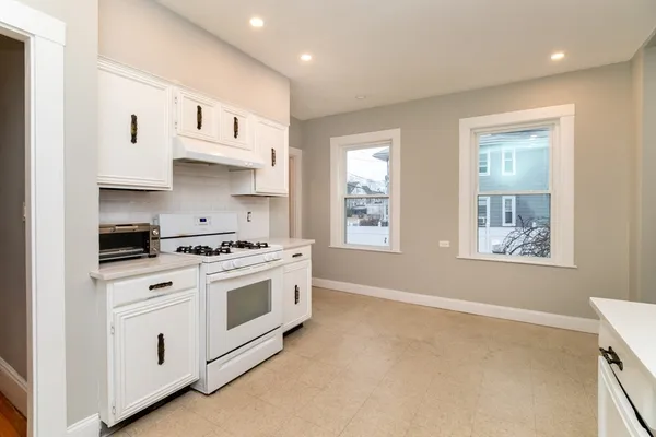 a kitchen with white cabinets and white appliances